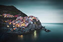 Town on cliff by sea at sunset in Manarola, Italy