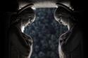 Sculptures of young women with halos face to face in shadow